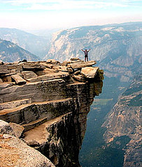 A man, arms eagle spread, at the top of the trail