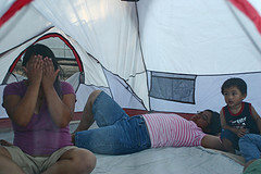 A family of three inside a big tent